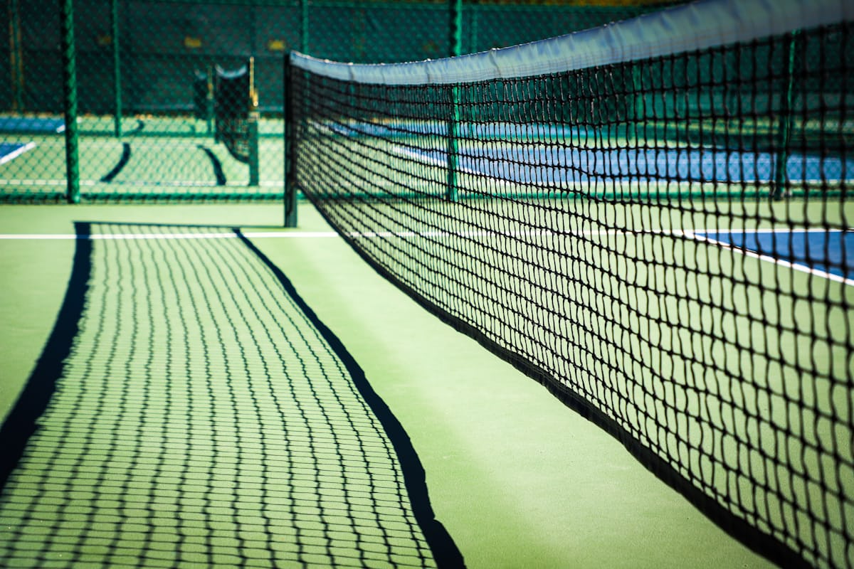 Primer plano de una red de pickleball en la línea de no volea, donde se deciden los golpes de control