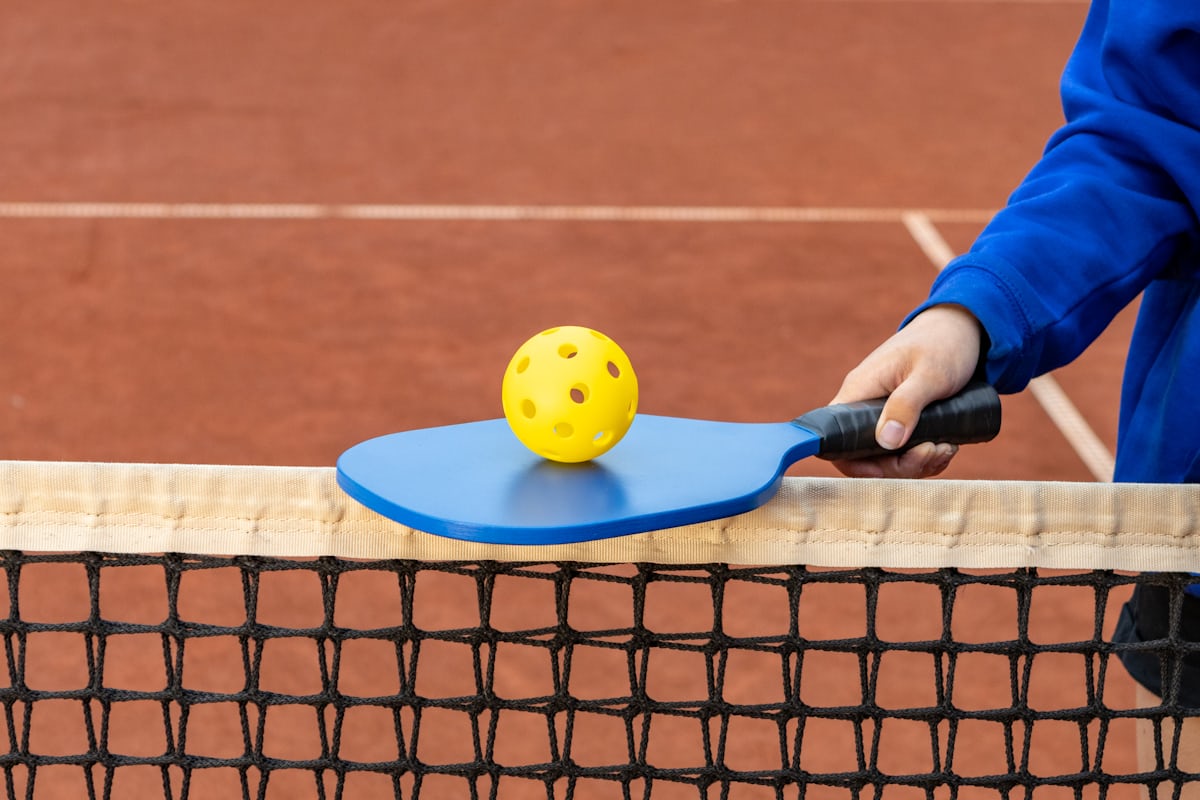 A player holding a pickleball paddle and ball, demonstrating a continental grip